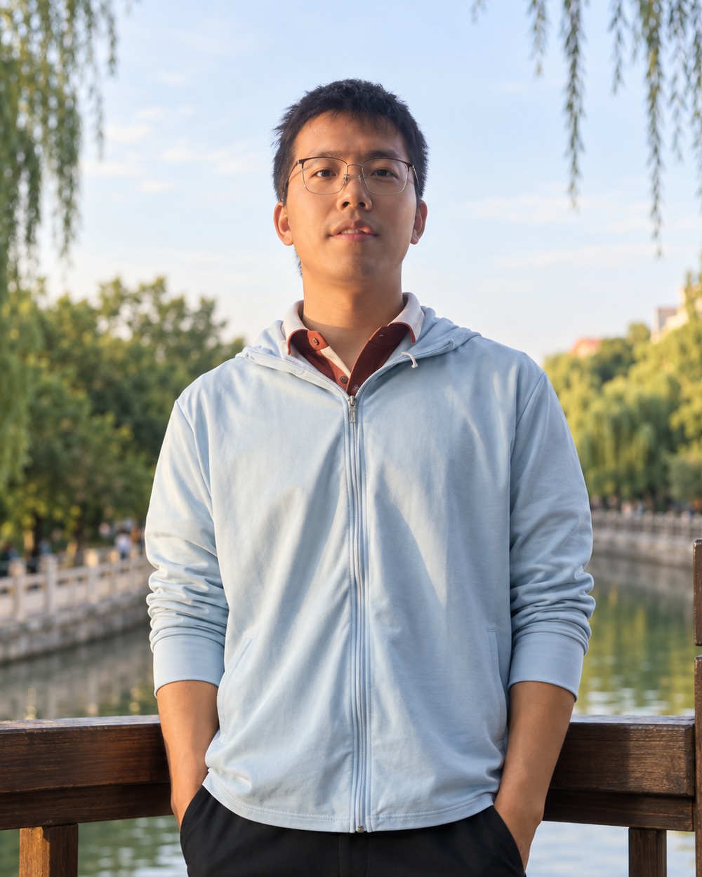 Han Dong standing outdoors beside a lakeside railing