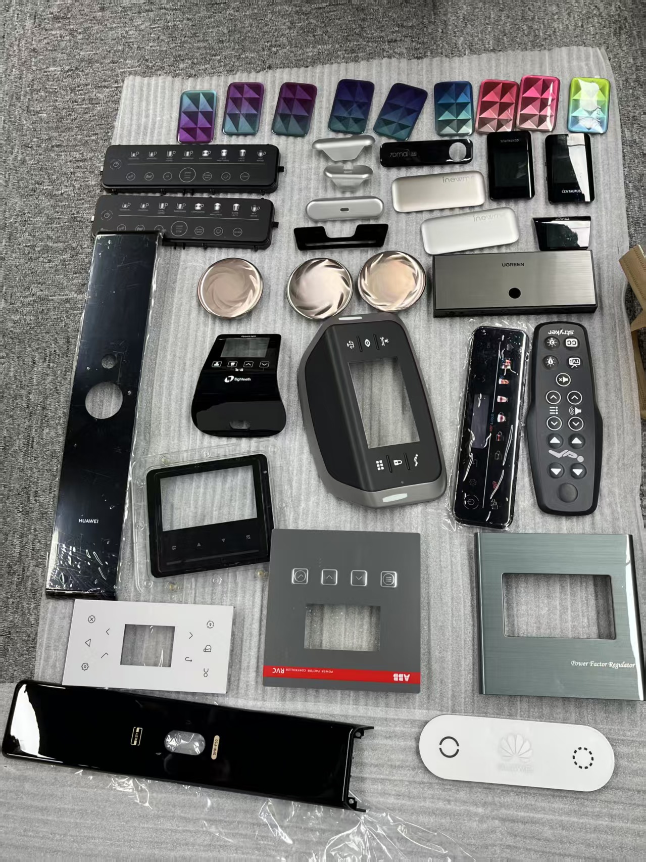 Owner-supplied photograph of product panels, plastic components, and CMF samples with third-party marks